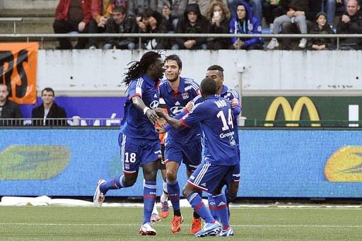 Lyon's Bafetimbi Gomis (L) celebrates with teammates after scoring